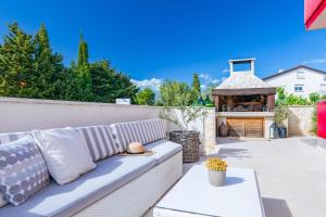 a white couch sitting on a patio with a gazebo at Apartments Mare in Punat