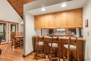 a kitchen with wooden cabinets and a bar with stools at SBL14 -Mayberry Lodge in Branson West