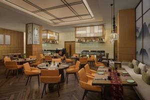 a restaurant with tables and chairs in a room at Surat Marriott Hotel in Surat