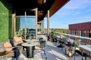 a patio with tables and chairs on a building at AC Hotel by Marriott Auburn in Auburn