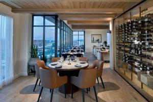 a dining room with a table and chairs and a wine cellar at AC Hotel by Marriott Auburn in Auburn