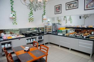 a restaurant with a table and a counter with food at Hotel Universitario in Itapetininga