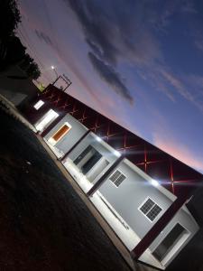 a white house with lights on the side of it at PousadaOasis in Várzea Grande