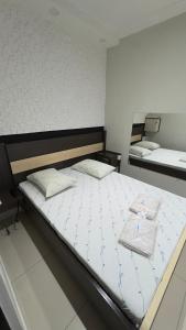 a bedroom with two beds with white sheets at Hotel Costa Leste in São Paulo