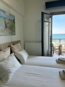 a bedroom with two beds with a view of the ocean at Makedos Sea View in Nea Vrasna