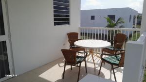 ein weißer Tisch und Stühle auf einem Balkon in der Unterkunft Rosa Brisa Apartment in Willemstad