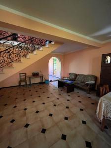a living room with a couch and a staircase at Rest house Keda in K'eda