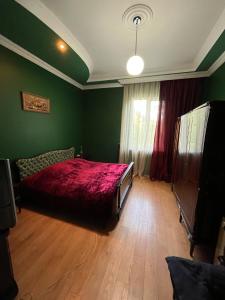 a bedroom with a red bed and a window at Rest house Keda in K'eda