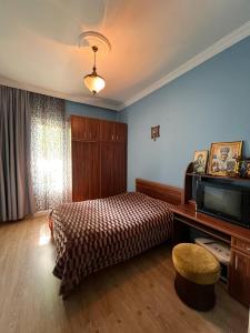 a bedroom with a bed and a television at Rest house Keda in K'eda