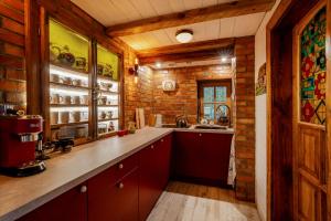 a kitchen with red cabinets and a brick wall at Tylko Dobro Dom Księżyca in Pabianice