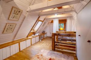 an attic room with white walls and wooden floors at Tylko Dobro Dom Księżyca in Pabianice
