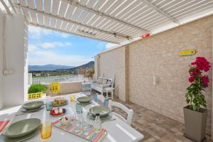 a white table with plates of food on a patio at Antigone's Blue Vista in Kampos Paros