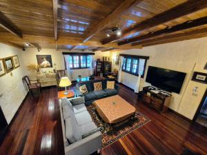 a living room with a couch and a tv at Villa Rural EL Poleo D&R con Piscina Climatizada Privada y Solárium in Pico de Viento