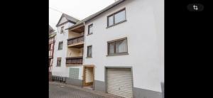 an image of a white house with a garage at Bella Vita Apartment due in Ediger-Eller