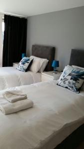 Duas camas sentadas uma ao lado da outra num quarto em Howlands Bright 2 bed 2 bath apartment balcony with views over town em Crawley