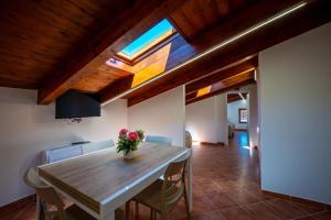 a dining room with a wooden table with a vase of flowers at Carlo's Luxury Villa in Agerola