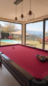 a pool table in a room with a view of a swimming pool at Caniçada Home in Vieira do Minho