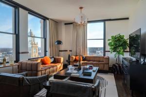 a living room with leather furniture and large windows at Surety Hotel, Autograph Collection in Des Moines