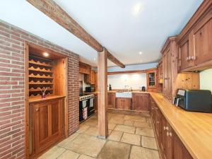 a kitchen with wooden cabinets and a brick wall at 4 Bed in Lymington oc-c41423 in Lymington