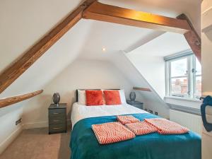 a bedroom with a bed with red pillows on it at 4 Bed in Lymington oc-c41423 in Lymington