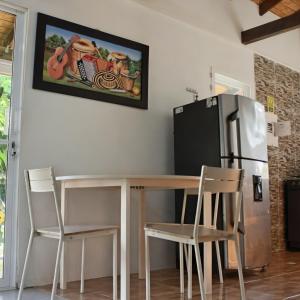 a kitchen with a table and chairs and a refrigerator at Cabañas Ismasoris in Providencia