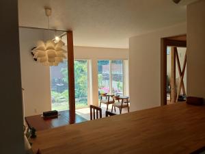 a dining room with a table and a chandelier at Guesthouse Oomiyabase25 大宮基地 別荘新館 in Chiba
