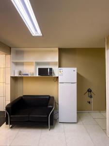 a living room with a black couch and a refrigerator at LOFT Centrico in Ciudad del Este
