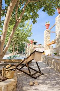 a wooden bench sitting under a tree with a basket at Boreas Retreat - Mountain Escape & Spa in Batroûn