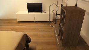 a room with a television on a dresser with a bed at NaturalmenteLucia in Cologno al Serio