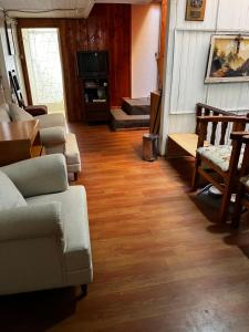 a living room with couches and a wooden floor at Hospedaje Lala in Villarrica