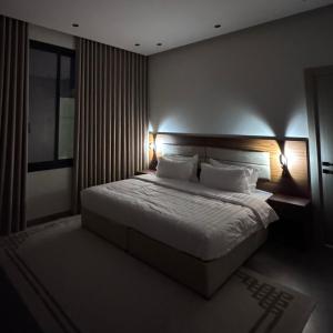 a bedroom with a large bed with two lamps at Misk Apartment in Jeddah