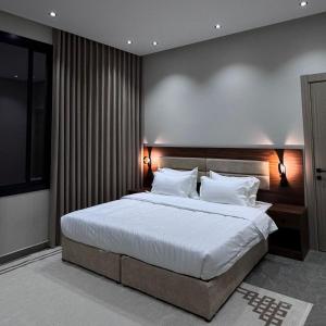 a bedroom with a large bed with white sheets and pillows at Misk Apartment in Jeddah