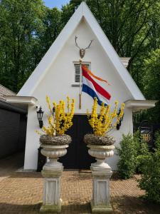 a house with a flag in front of it at B&B Huisje Schaufeli in Apeldoorn