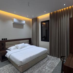 a bedroom with a large white bed and a window at Misk Apartment in Jeddah