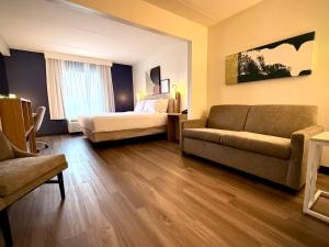 a living room with a bed and a couch at Spark by Hilton Waynesboro in Waynesboro