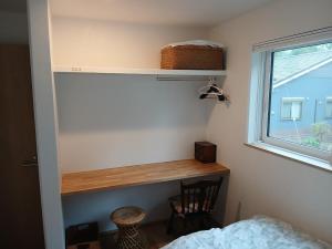 a bedroom with a desk next to a window at Guesthouse Oomiyabase25 大宮基地 別荘新館 in Chiba