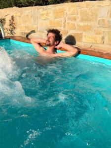 Ein Mann schwimmt in einem Schwimmbecken in der Unterkunft Villa Dedo in Reggello