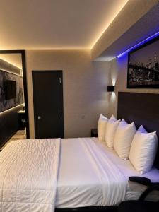 a hotel room with a large bed with white pillows at The Vine Hotel Bronx New in Bronx