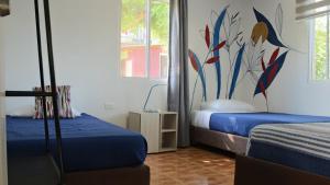 a bedroom with two beds and a painting on the wall at Cabañas Ismasoris in Providencia