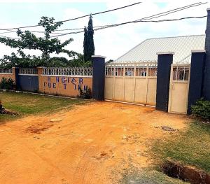 a fence in front of a building with graffiti on it at Hanover Hotels Suleja in Tunga Bai