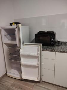 an open refrigerator in a kitchen with a microwave at Casona Villa Helena in Miramar