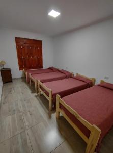 a room with four beds with red covers in it at Casona Villa Helena in Miramar