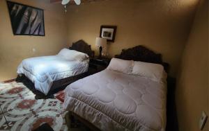 a bedroom with two beds and a rug at Posada Las Reynas in Mineral de Pozos