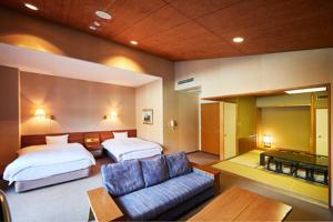 a hotel room with two beds and a couch at Shiki Resort Ventvert Karuizawa in Karuizawa