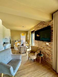 a living room with a couch and a tv on a brick wall at Quinta Santo Antonio in Gouveia