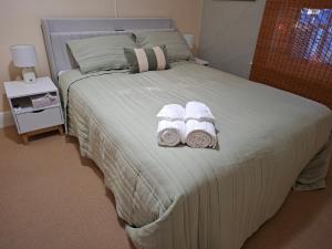 a bedroom with a large bed with towels on it at Woodhill Way Burra in Burra