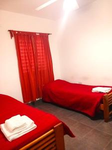 a room with two beds and a red curtain at El Recodo in La Rioja +6 photos