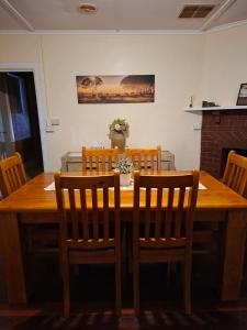 a dining room table with four chairs and a wooden table at Woodhill Way Burra in Burra