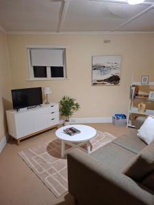 a living room with a couch and a table at Woodhill Way Burra in Burra