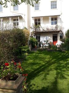 a garden in front of a white building at private room in Leamington Spa